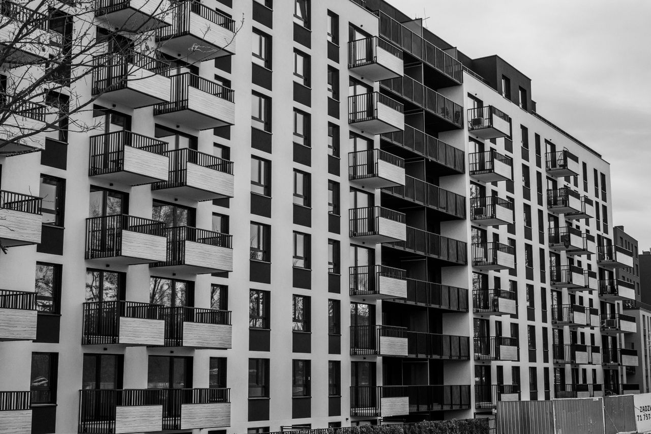 programs-03 Black and white photo of a contemporary apartment building with multiple balconies.