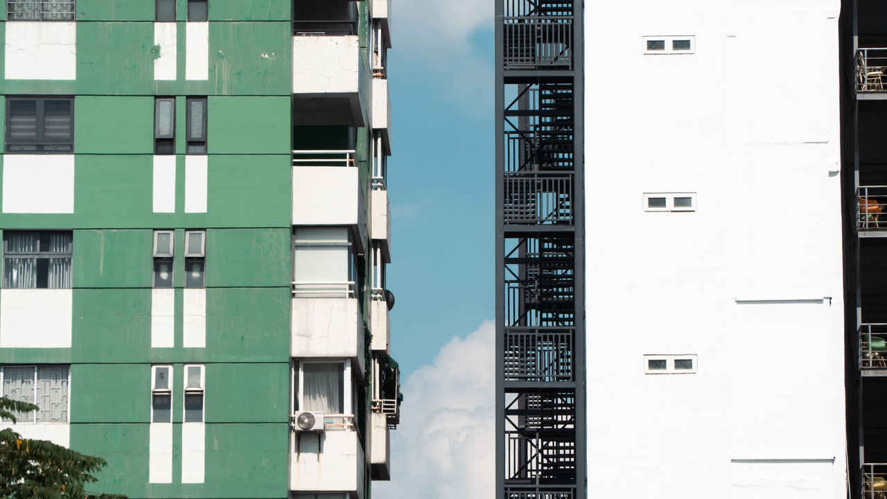 programs-01 Urban architecture featuring contrasting building facades under a clear blue sky.